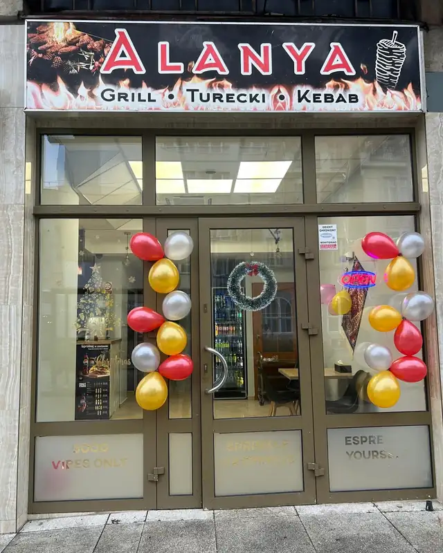 Wejście do lokalu z czerwonym szyldem ALANYA Grill Turecki Kebab